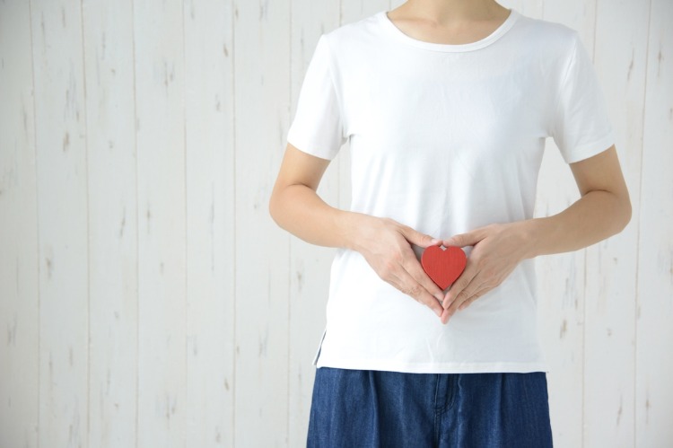 woman in white t shirt holding a red heart