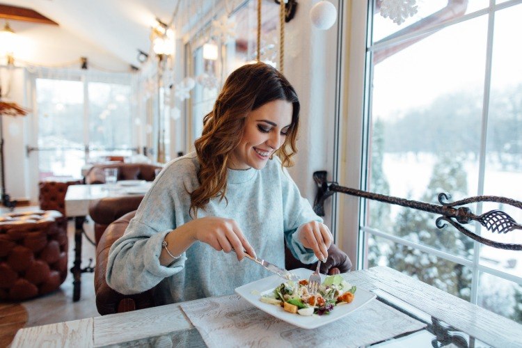 woman eating vegetarian salad in a restaurant