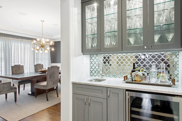 butlers pantry with mirror backsplash and grey cabinets
