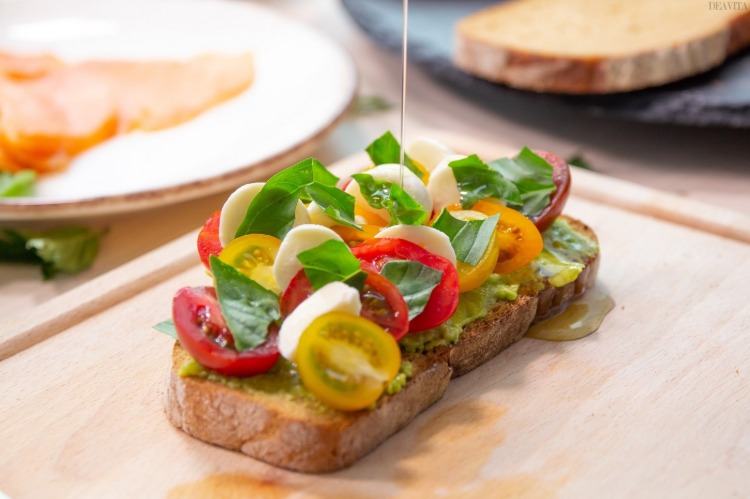 caprese on slice of bread with colorful cherry tomato mozzarella and basil