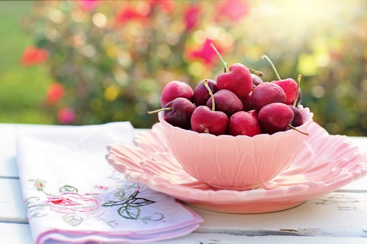 fresh cherries in pink bowl on a table 