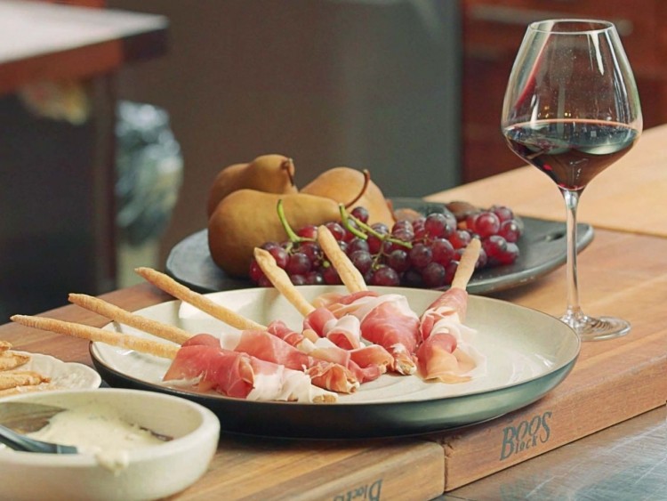 prosciutto wrapped grissini served with grapes and wine