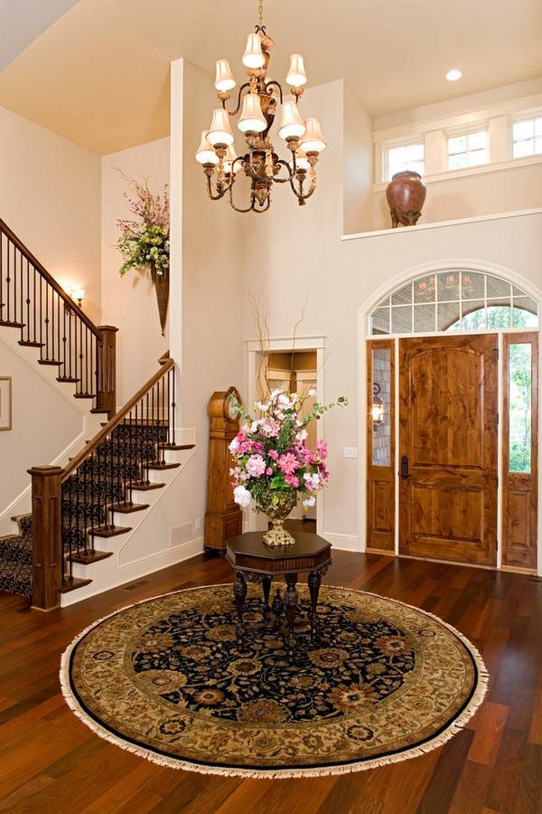elegant entryway hallway with round carpet and small table