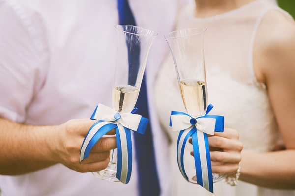 Bride and groom holding beach themed decorated wedding glasses