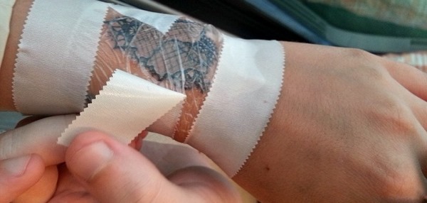 cover new tattoo with cling film or bandage to protect against bacteria
