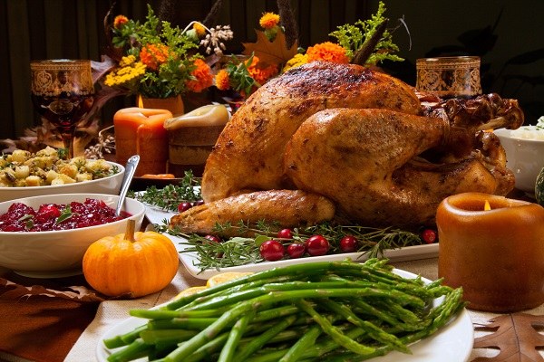 thanksgiving dinner table with roasted turkey and side dishes