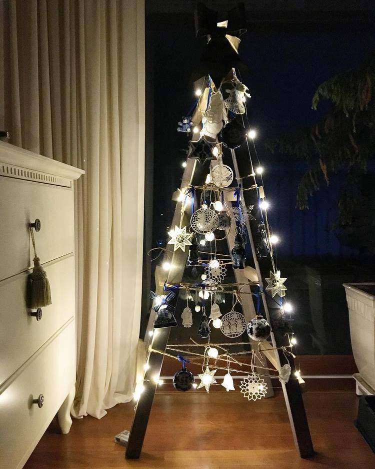 wooden ladder decorated with Christmas lights and tree ornaments