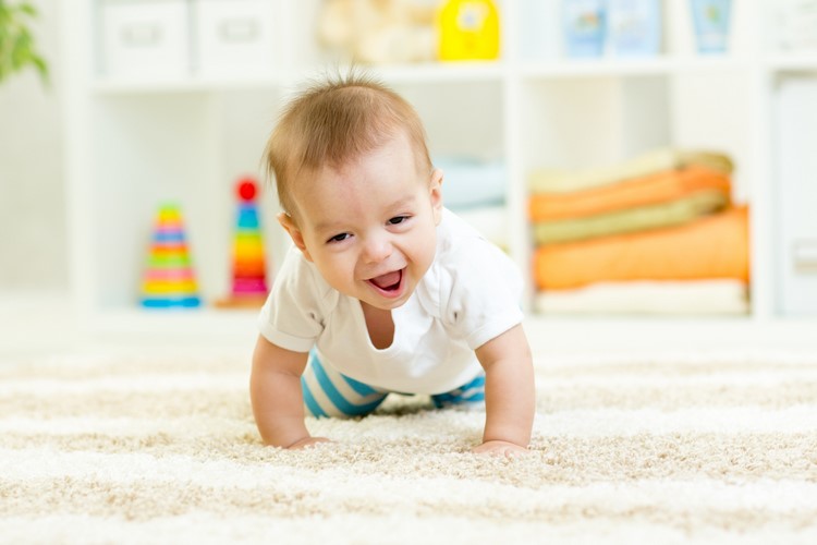 baby crawling on the carpet in nursery room