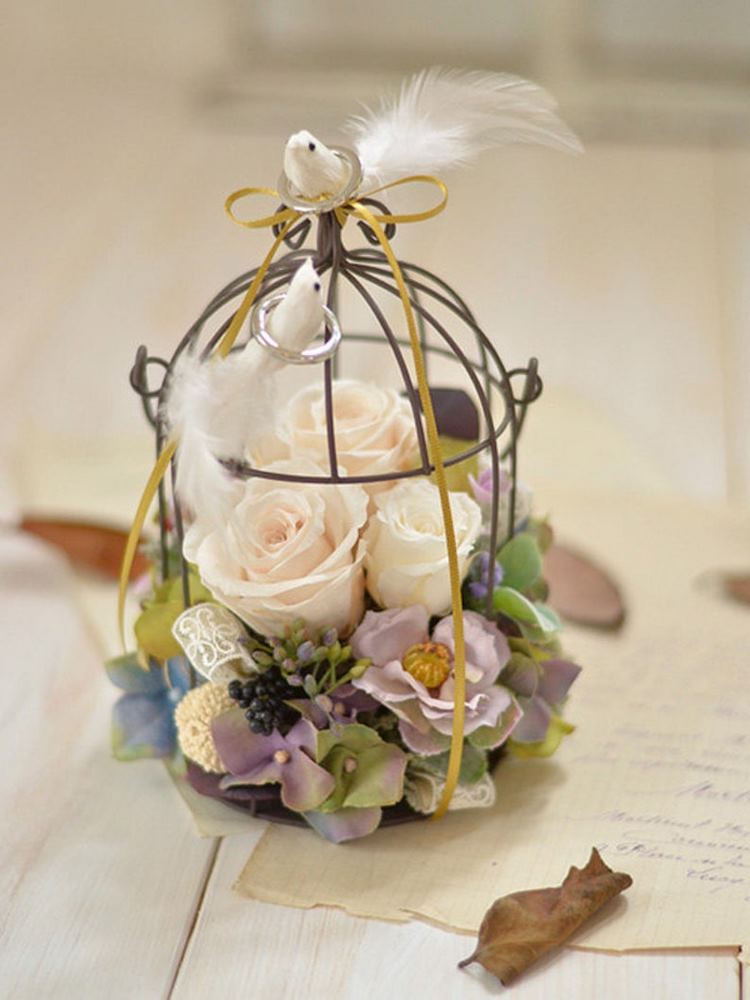 birdcage decorated with flowers and white birds as a ring holder