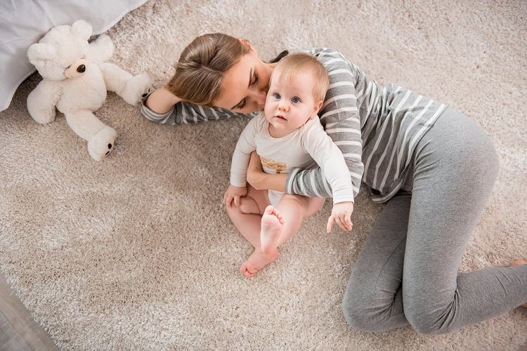 mother and baby playing on soft carpet