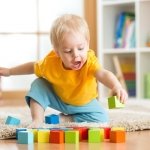 toddler-playing-with-cubes-on-the-floor-in-the-nursery-room