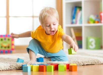 toddler-playing-with-cubes-on-the-floor-in-the-nursery-room