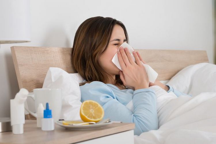 woman in bed flu cough take vitamins