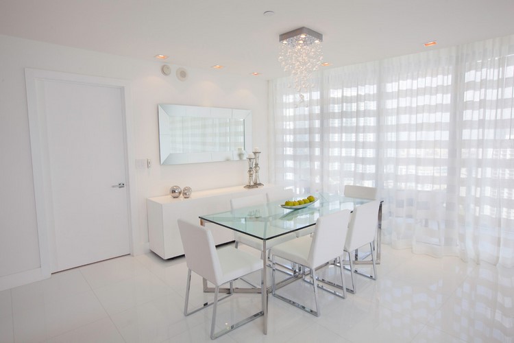 white dining room with glass table top and modern chairs