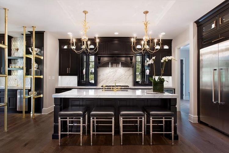 black kitchen island white countertop and gold chandeliers