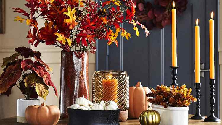 elegant and stylish fall decoration with colored leaves and candles