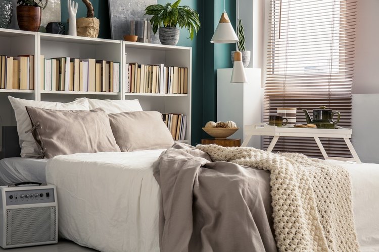 small bedroom with bookcase as headboard