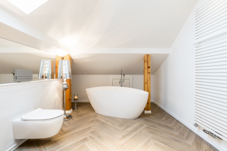 white attic bathroom with freestanding bathtub