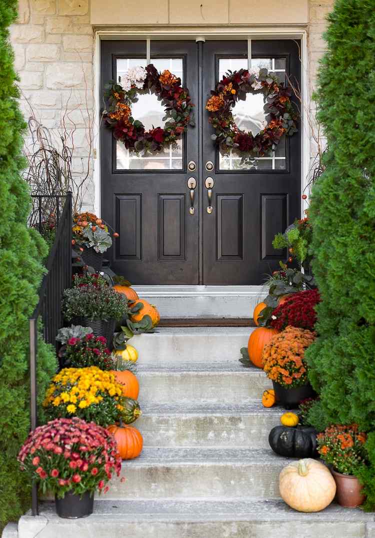 front door and stairs fall decor pumpkins flowers and wreaths