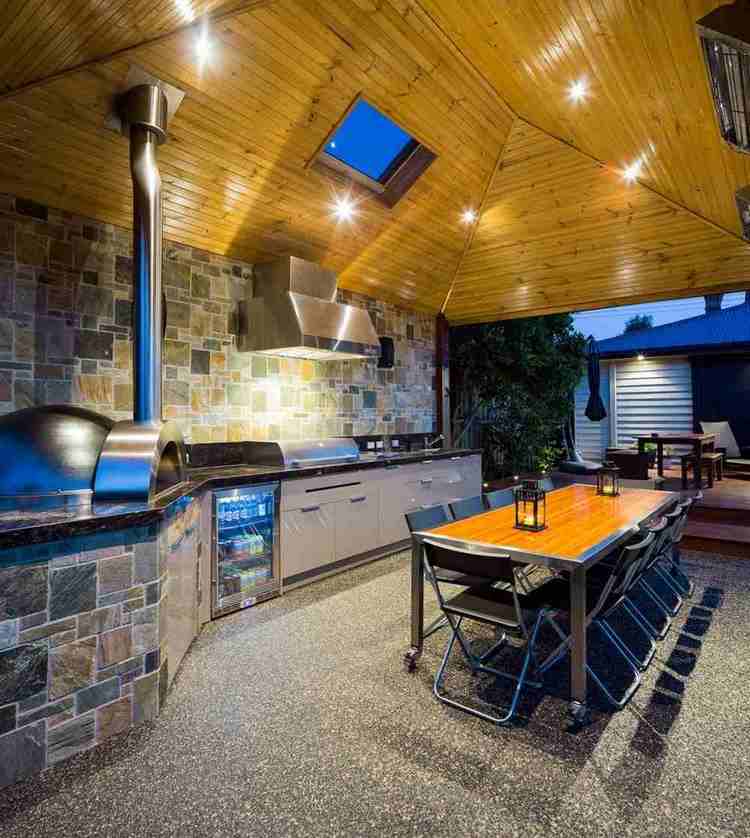 covered outdoor kitchen with skylight window built in fridge dining table