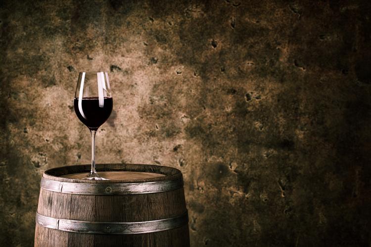 glass of red wine on barrel home cellar design