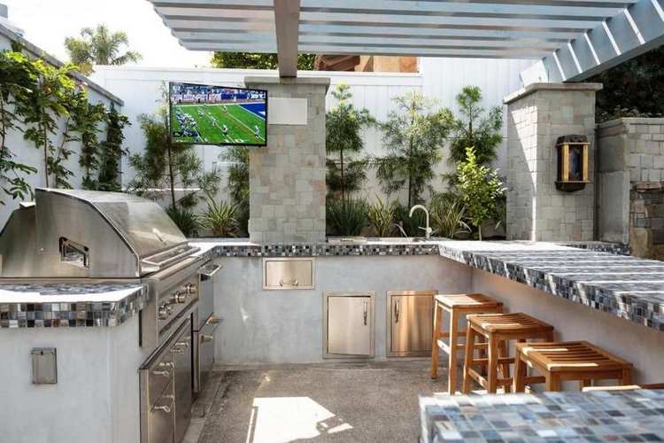 outdoor kitchen with gas grill tv for more entertainment when barbecuing and tiled bar counter