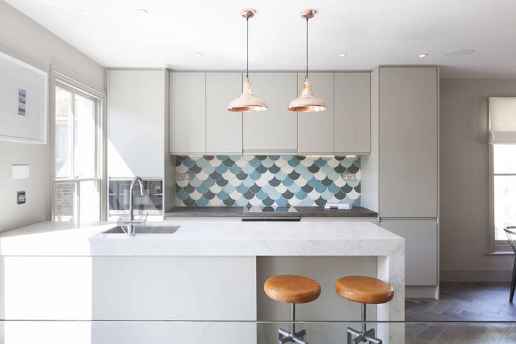 white kitchen cabinets and tile backsplash with fish scale pattern