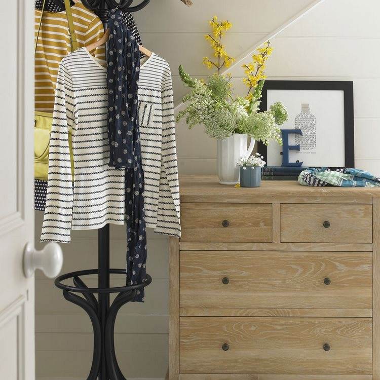 hallway with chest of drawers and freestanding coat rack