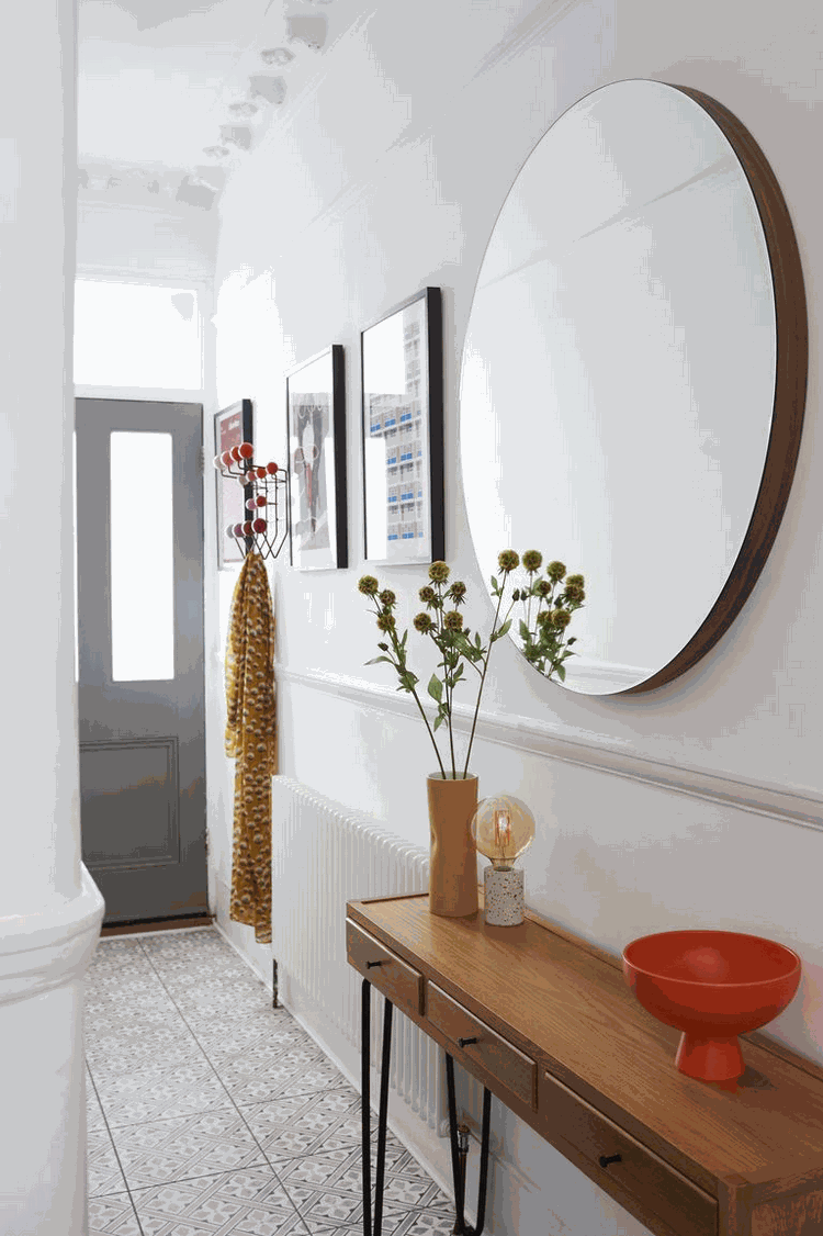 large mirror and console table with hairpin legs in narrow hallway