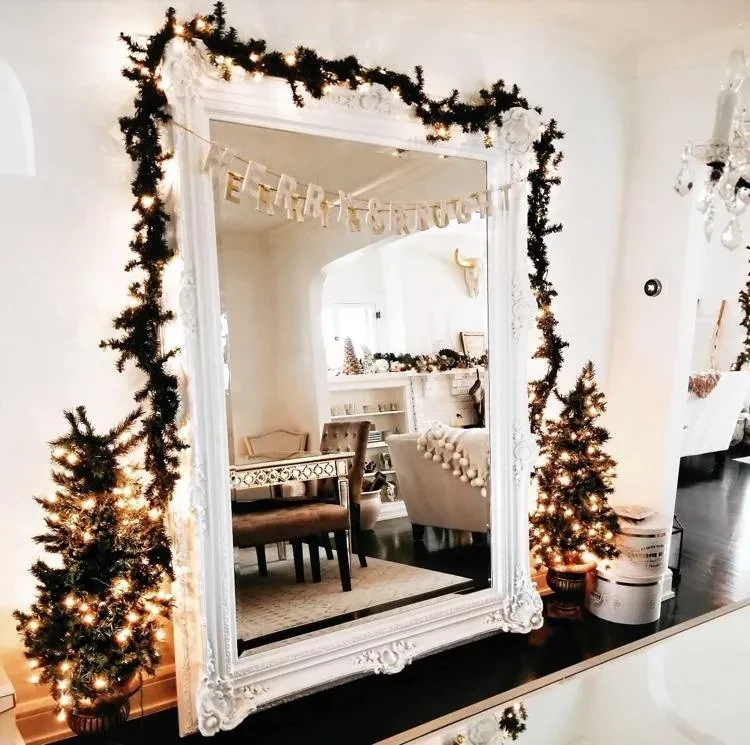 Decorating mirrors for Christmas with fairy lights and garlands