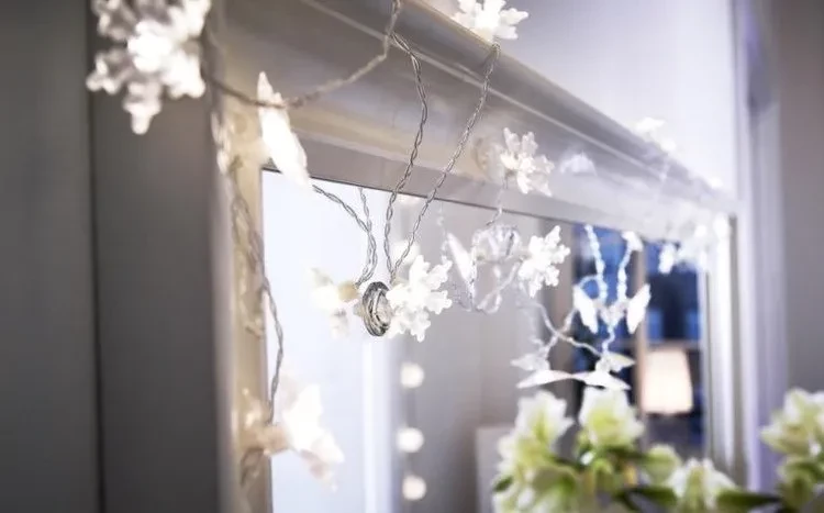 Decorating mirrors for Christmas with snowflakes fairy lights