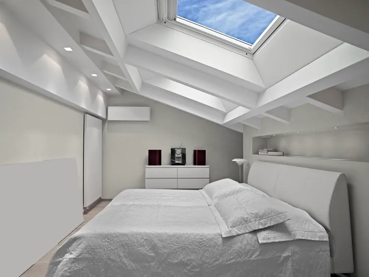 attic bedroom with skylight and recessed lights