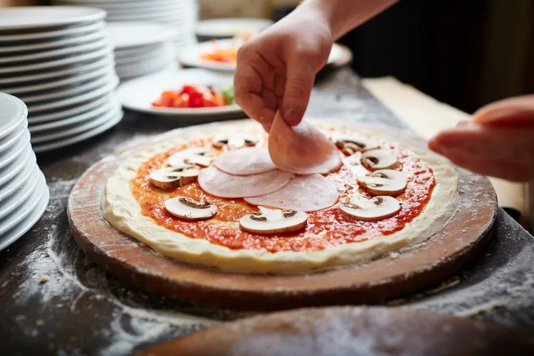 preparing pizza with tomato sauce mushrooms