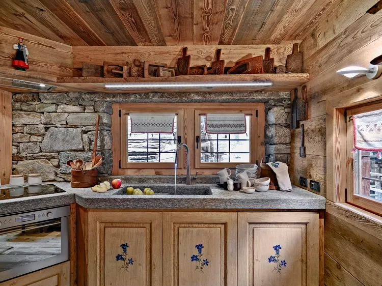 rustic kitchen with wooden ceiling stone walls