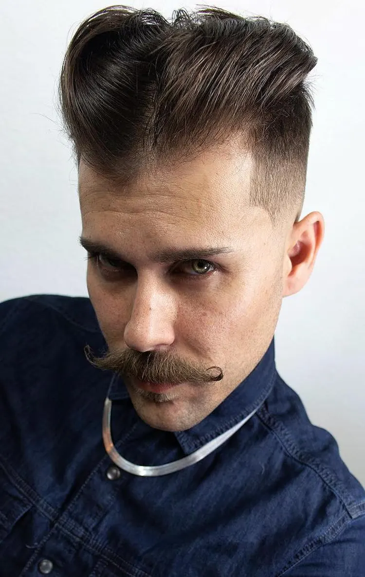 hipster mens haircut with center part on top of the head and mustache