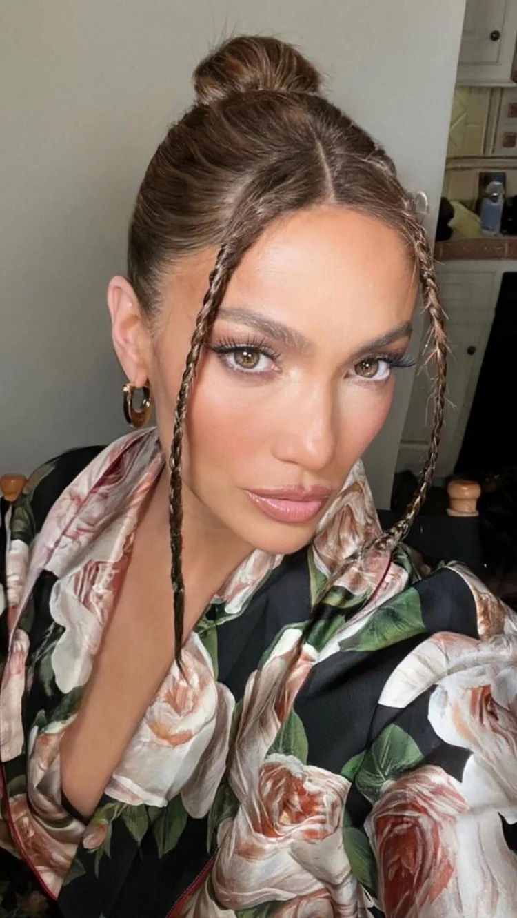 J Lo wears a high bun with casually falling braids