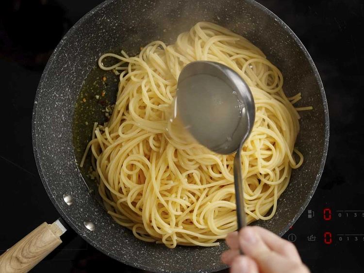 Pour starchy pasta water into the pan