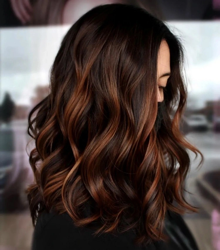 Warm up your brunette hair with fiery shades of honey blonde