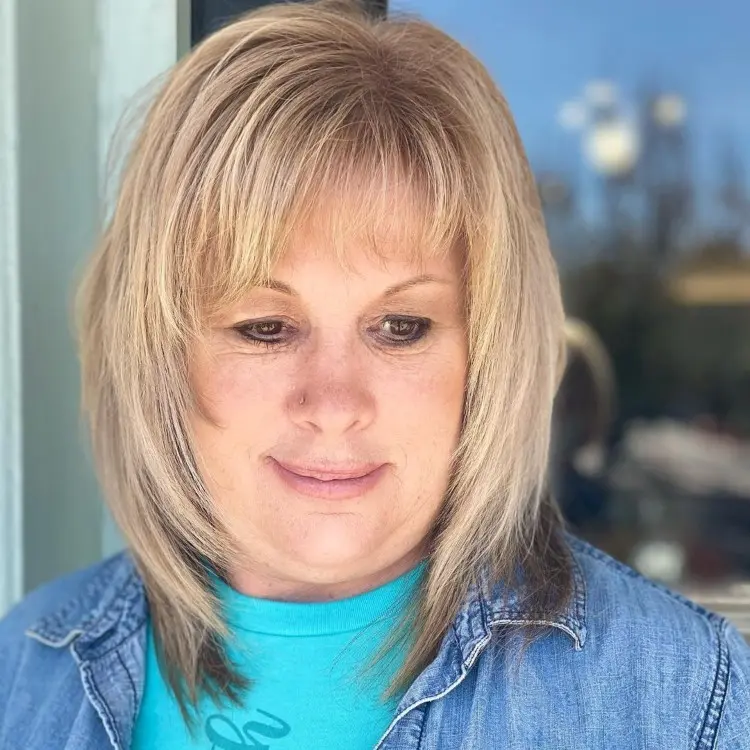 layered haircuts for women over 50 with bangs