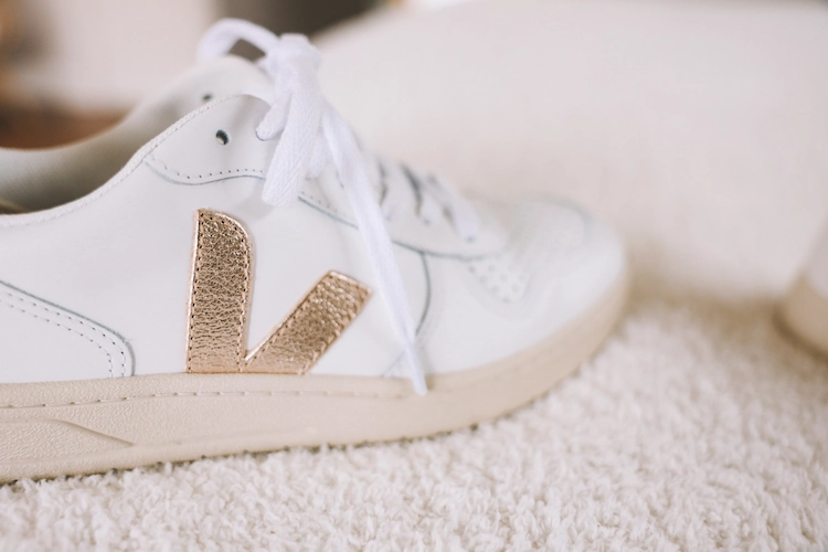 white sneaker trends 2022 with golden accents and cream sole
