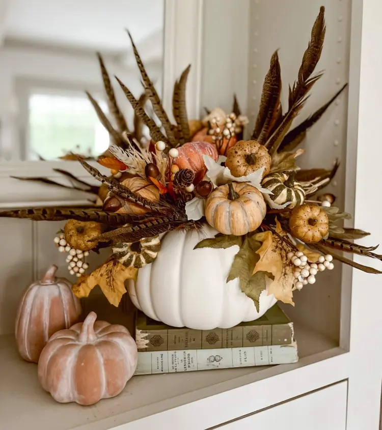 DIY arrangement in a pumpkin vase decorative leaves and feathers