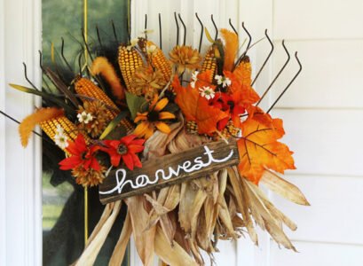 DIY-outdoor-fall-decoration-with-a-rake-and-artificial-flowers