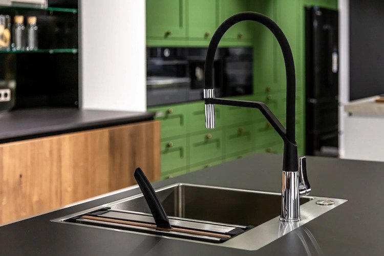 kitchen faucet in matt black in combination with green kitchen cabinets