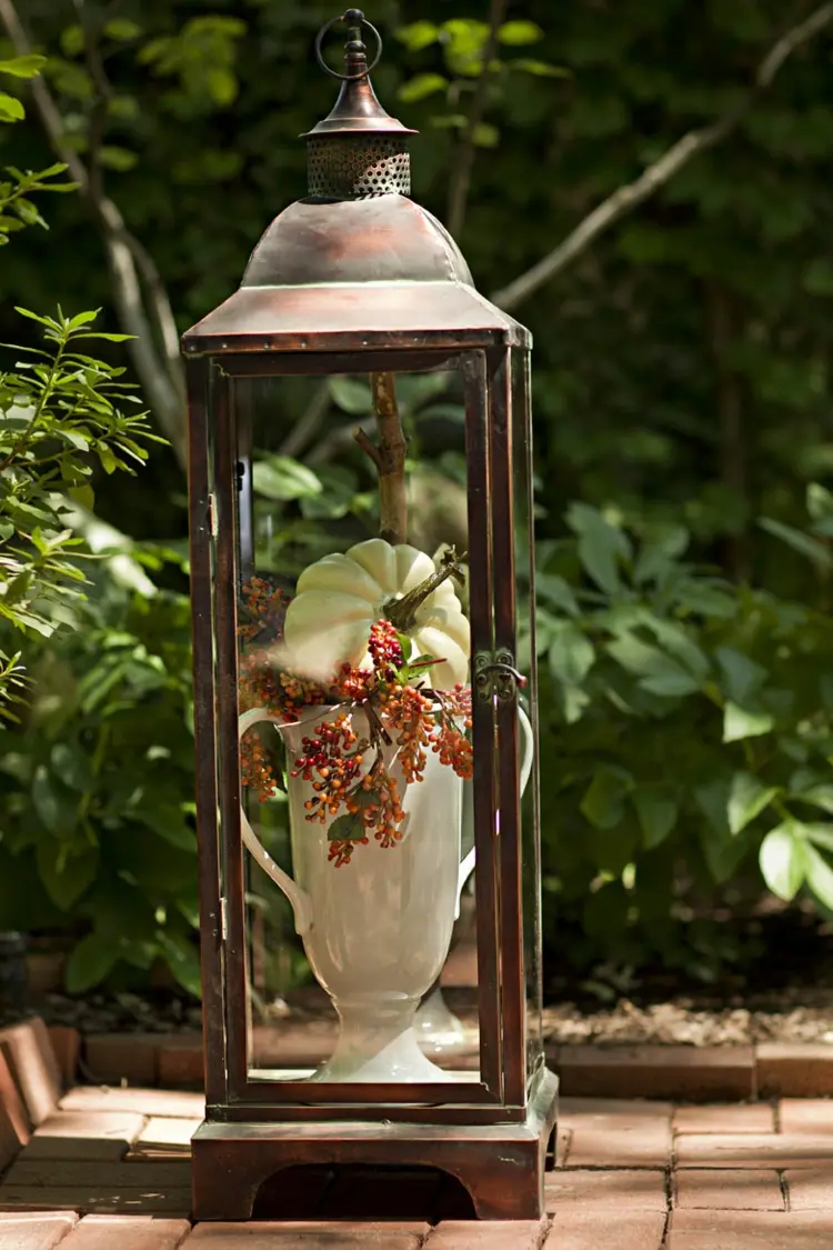 Big vase in a metal lantern with berries and twigs