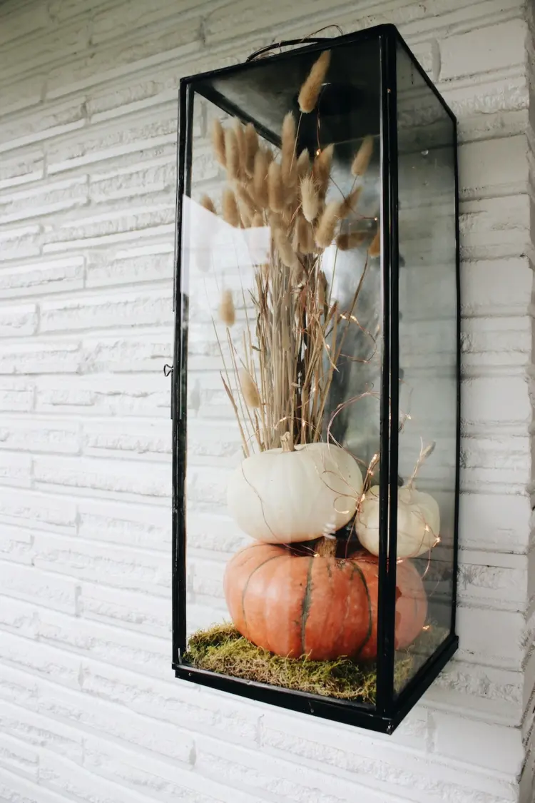 Decorate a lantern for fall with grasses and pumpkins
