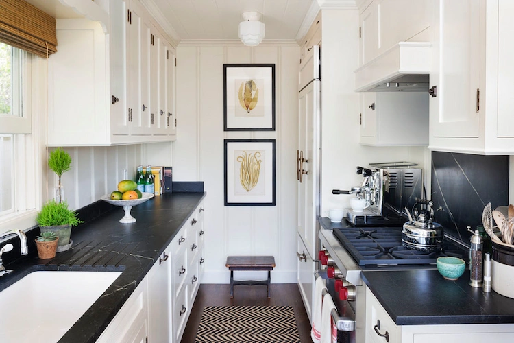 small kitchen with dark worktops and white cabinets