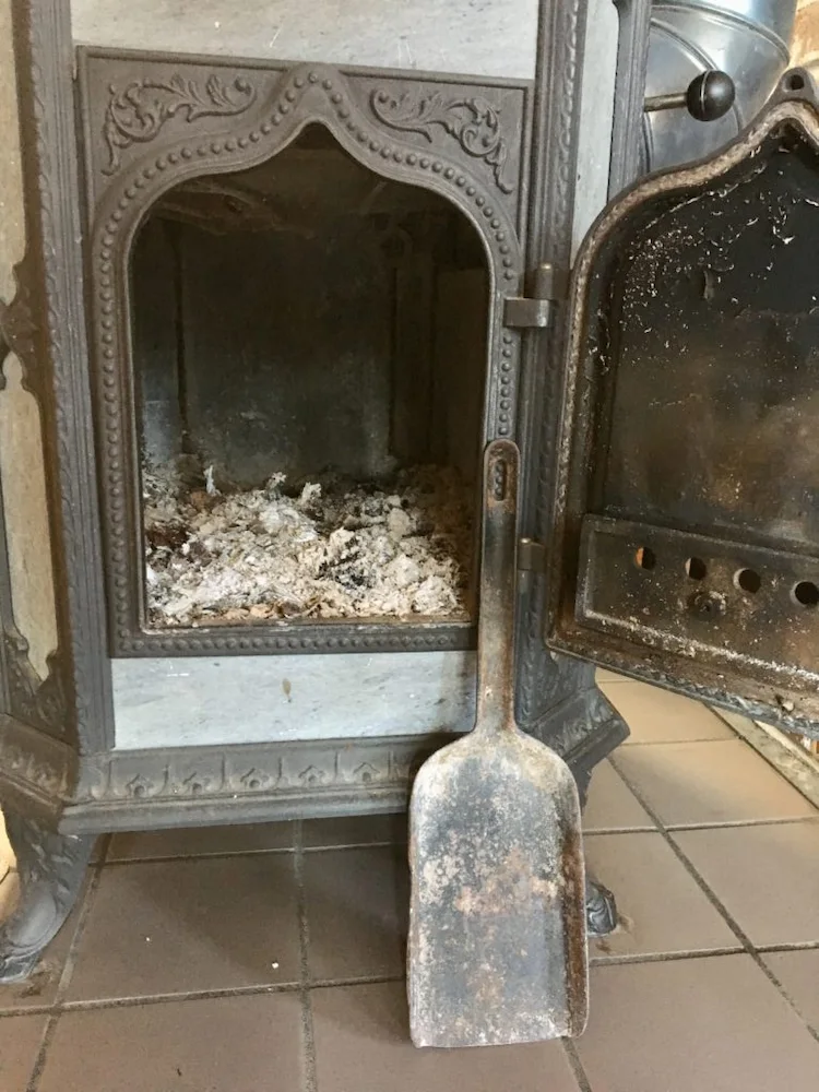 Regularly dispose of ashes from a firebox of wood stove with an ash shovel