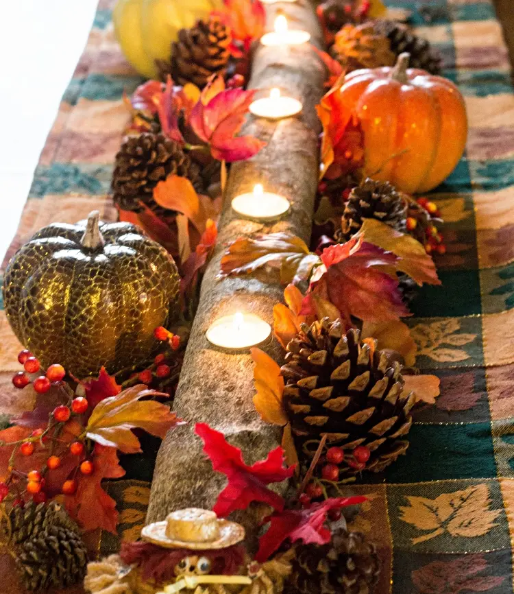 log centerpiece with tea candles cones pumpkins red leaves