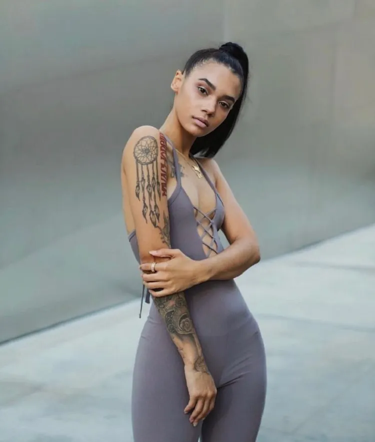 what black tattoo on dark skin woman forearm