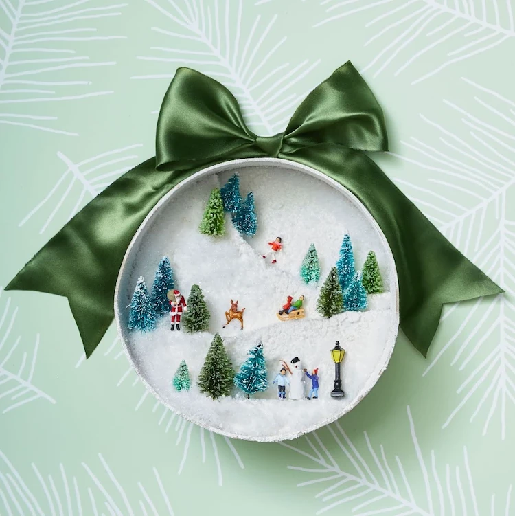Transform a round gift box with styrofoam and figurines into a snowy sleigh scene